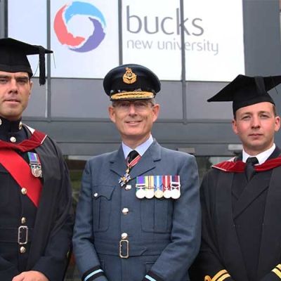 Air Commodore Richard Hill stood in the middle of two male graduates